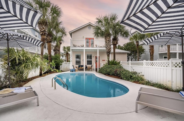 pool at dusk with a patio