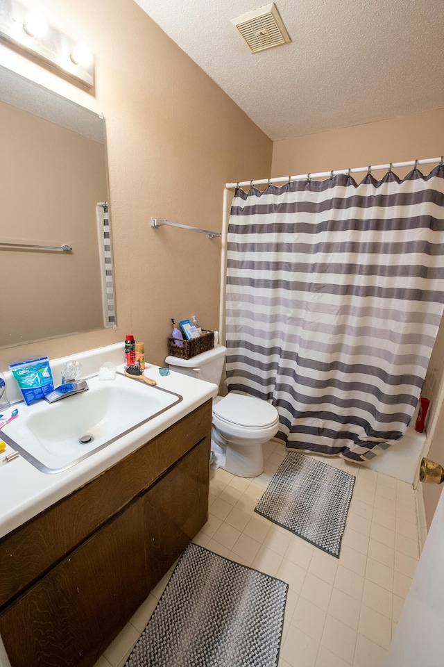 bathroom with curtained shower, tile patterned floors, a textured ceiling, toilet, and vanity