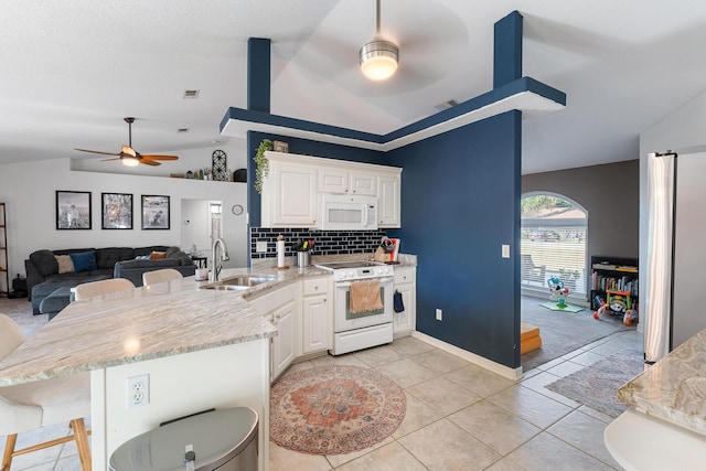 kitchen featuring sink, a kitchen breakfast bar, kitchen peninsula, white appliances, and white cabinets