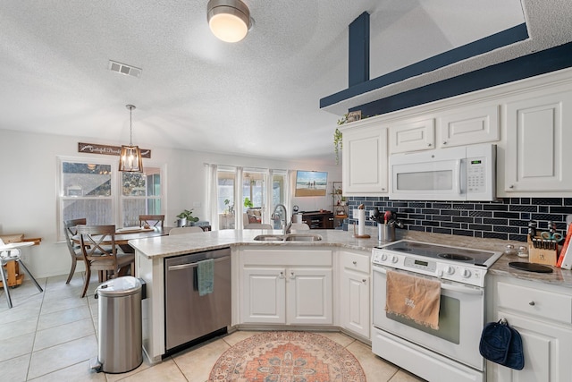 kitchen featuring kitchen peninsula, white appliances, sink, light tile patterned floors, and white cabinetry