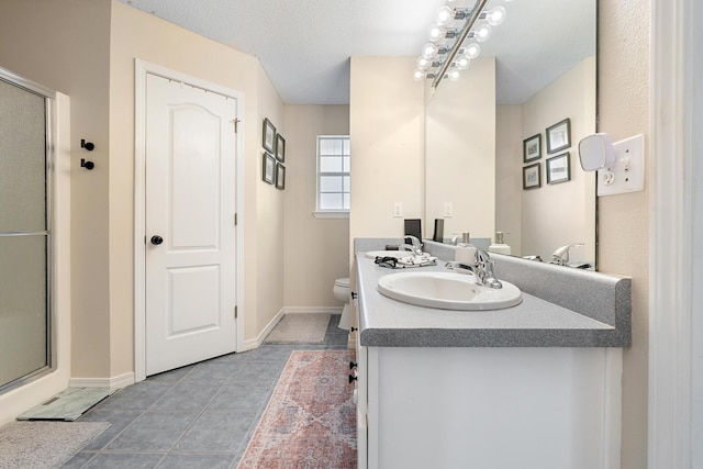 bathroom with tile patterned flooring, vanity, toilet, and walk in shower