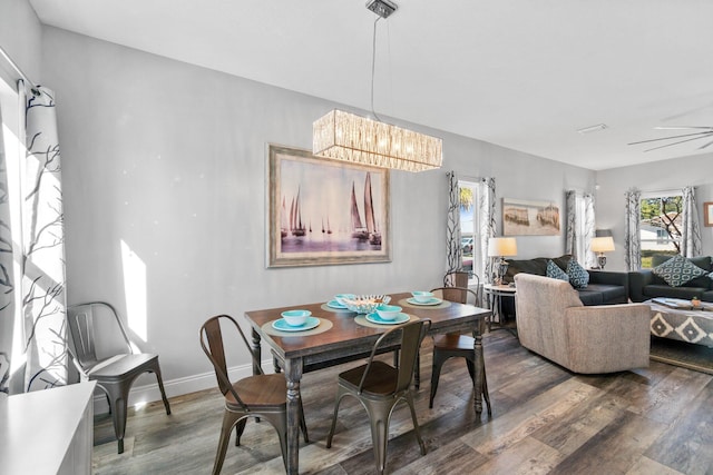 dining room featuring wood-type flooring and ceiling fan with notable chandelier