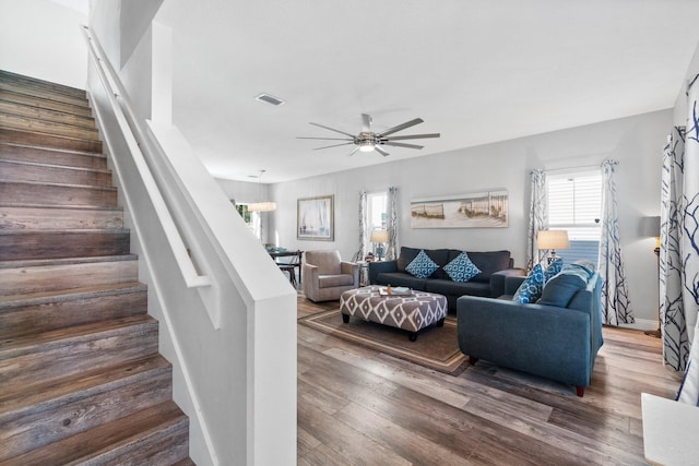 living room featuring ceiling fan, dark wood-type flooring, and a healthy amount of sunlight