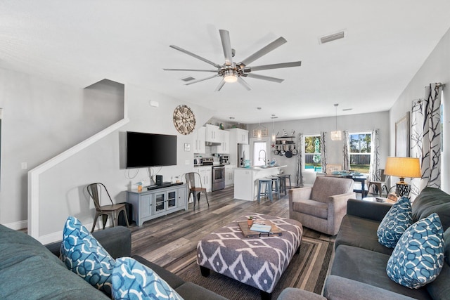 living room featuring ceiling fan, dark wood-type flooring, and sink