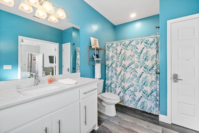 bathroom with hardwood / wood-style floors, vanity, toilet, and a shower with curtain