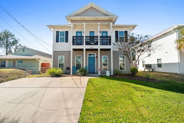 view of front facade featuring a balcony and a front yard