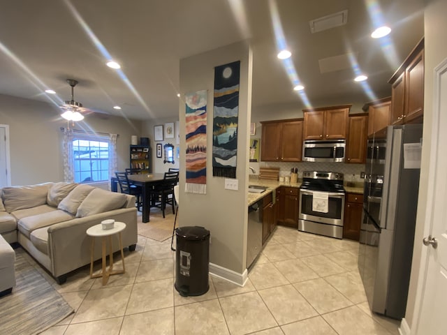 kitchen with appliances with stainless steel finishes, tasteful backsplash, ceiling fan, sink, and light tile patterned floors