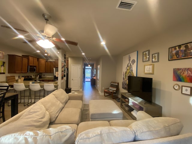 living room with ceiling fan and light tile patterned floors