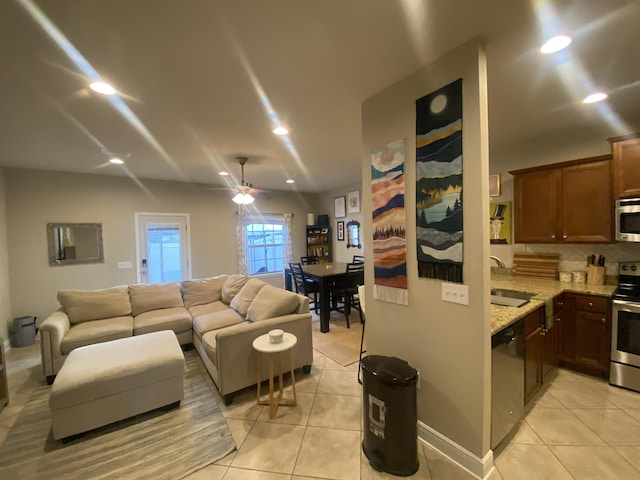 tiled living room with ceiling fan and sink