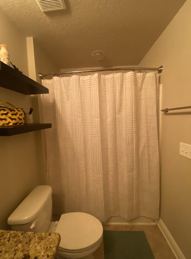 bathroom featuring a textured ceiling and toilet