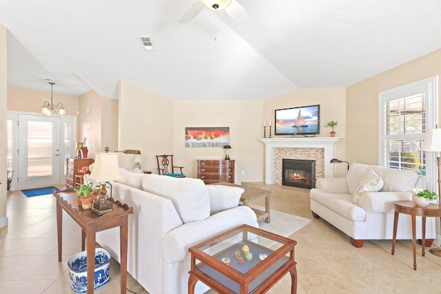 living room with vaulted ceiling, ceiling fan with notable chandelier, and light tile patterned floors