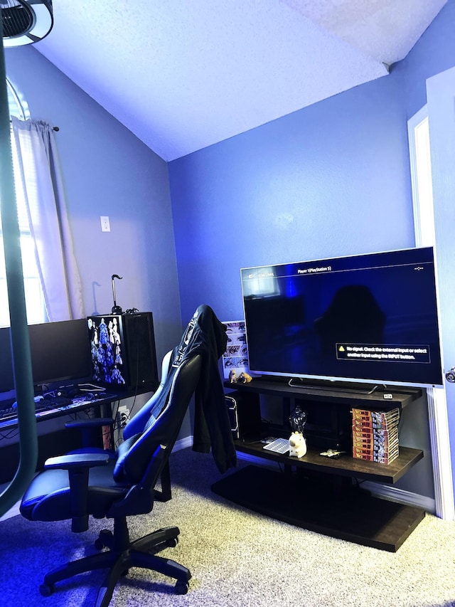 carpeted office with a textured ceiling and vaulted ceiling