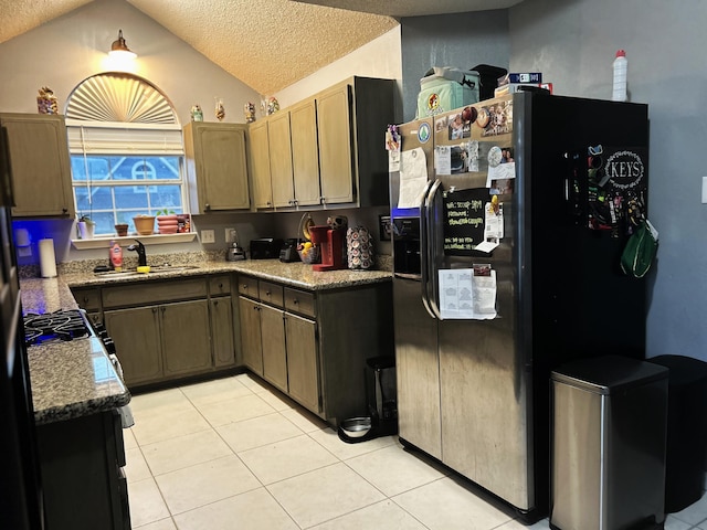 kitchen featuring lofted ceiling, sink, a textured ceiling, light tile patterned flooring, and stainless steel fridge with ice dispenser