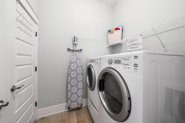 washroom featuring wood-type flooring and separate washer and dryer