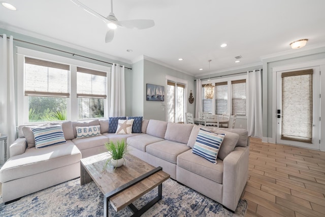 living room with crown molding, ceiling fan, and wood-type flooring