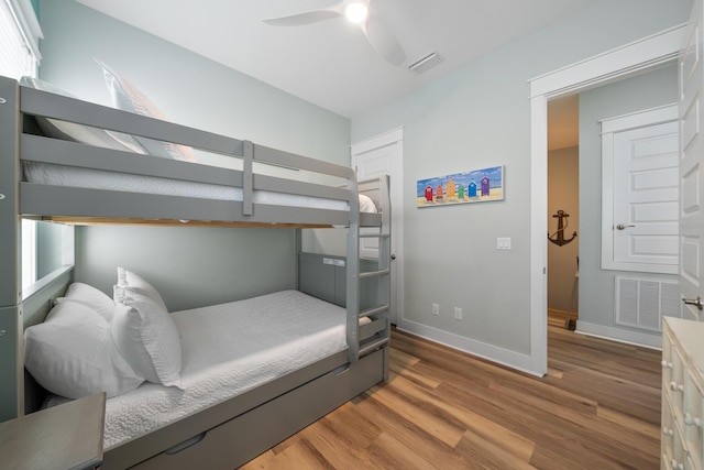 bedroom featuring multiple windows, ceiling fan, and hardwood / wood-style floors