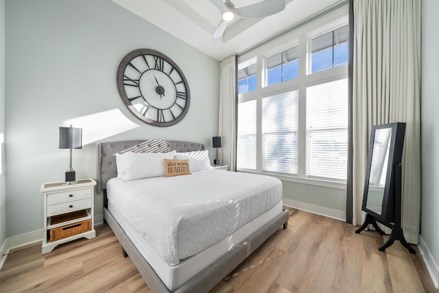 bedroom featuring ceiling fan, light hardwood / wood-style floors, and multiple windows