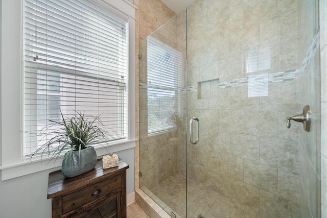 bathroom with a wealth of natural light and a shower with shower door