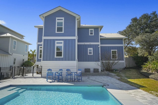 rear view of property featuring a fenced in pool, cooling unit, and a patio