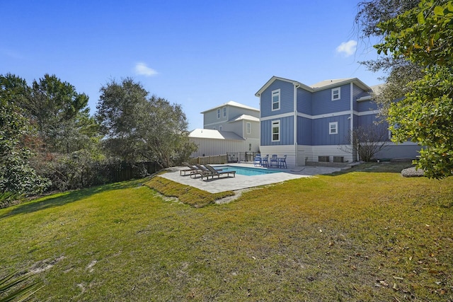 back of house featuring a fenced in pool, a yard, and a patio