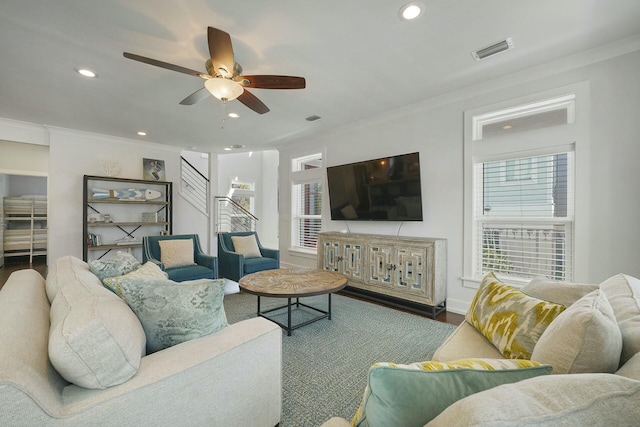 living room with ceiling fan, crown molding, and dark wood-type flooring