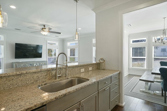 kitchen featuring light stone countertops, dark hardwood / wood-style flooring, a healthy amount of sunlight, and sink