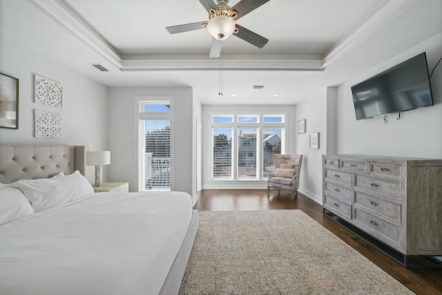 bedroom with a tray ceiling, ceiling fan, crown molding, and dark wood-type flooring