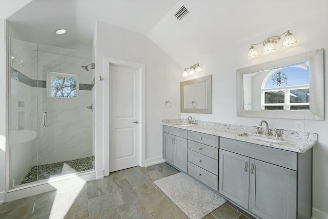 bathroom featuring vanity, a shower with shower door, and lofted ceiling