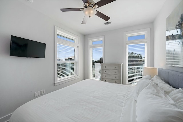 bedroom with ceiling fan and multiple windows