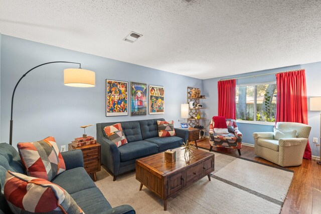 living room featuring light hardwood / wood-style flooring and a textured ceiling