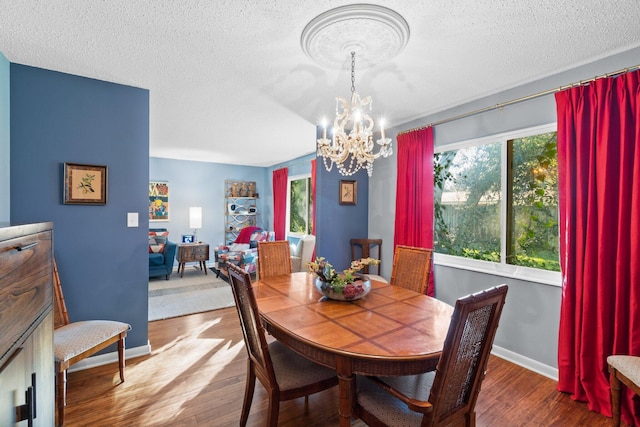 dining area featuring hardwood / wood-style floors, a textured ceiling, and an inviting chandelier