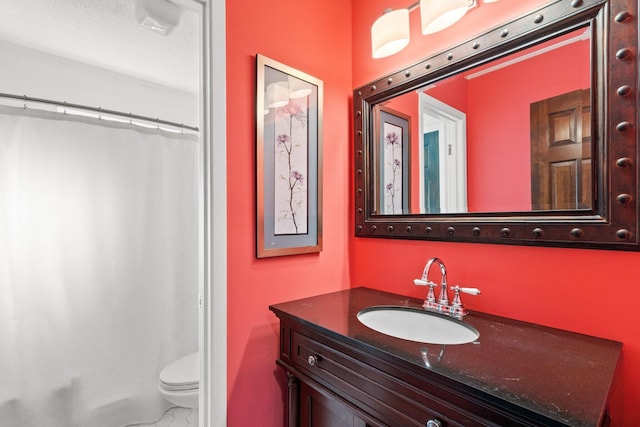 bathroom featuring a textured ceiling, vanity, toilet, and walk in shower