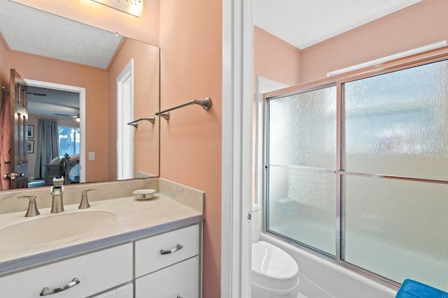 bathroom with combined bath / shower with glass door, vanity, and a textured ceiling