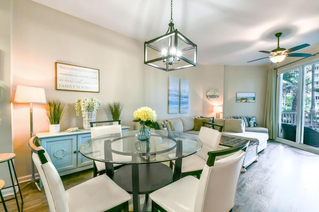 dining space with hardwood / wood-style floors and ceiling fan with notable chandelier