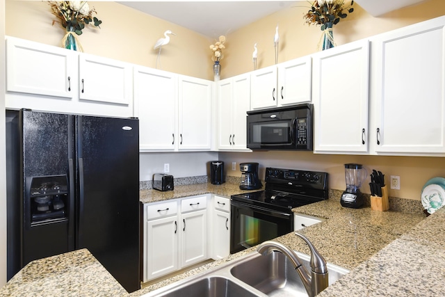 kitchen with white cabinets, sink, light stone countertops, and black appliances