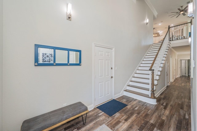 entryway with crown molding, ceiling fan, and dark wood-type flooring