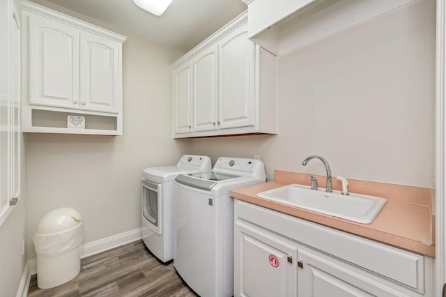 washroom featuring dark wood-type flooring, cabinets, sink, and washer and dryer