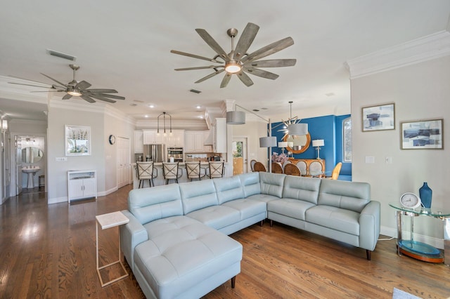 living room with wood-type flooring, plenty of natural light, and crown molding