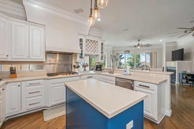 kitchen featuring white cabinetry, a kitchen island, stainless steel appliances, and decorative light fixtures