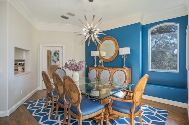 dining area featuring dark hardwood / wood-style floors, crown molding, and a notable chandelier