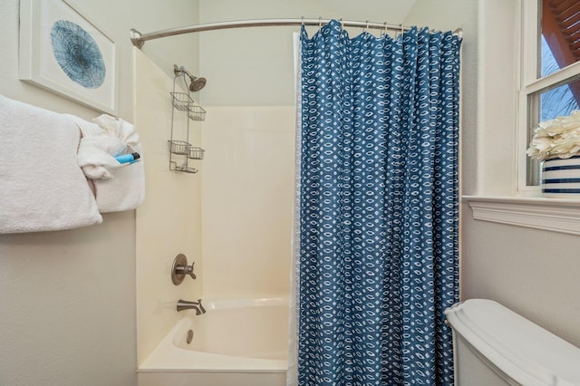 bathroom featuring shower / bath combination with curtain and toilet