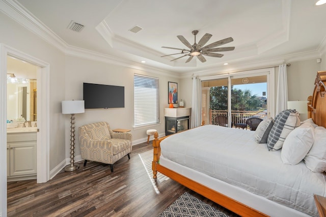 bedroom featuring access to outside, ceiling fan, connected bathroom, a tray ceiling, and dark hardwood / wood-style flooring