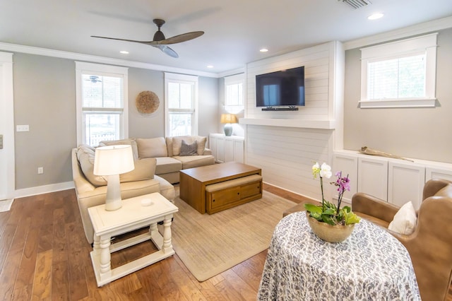 living room featuring ceiling fan, wood-type flooring, ornamental molding, and a wealth of natural light