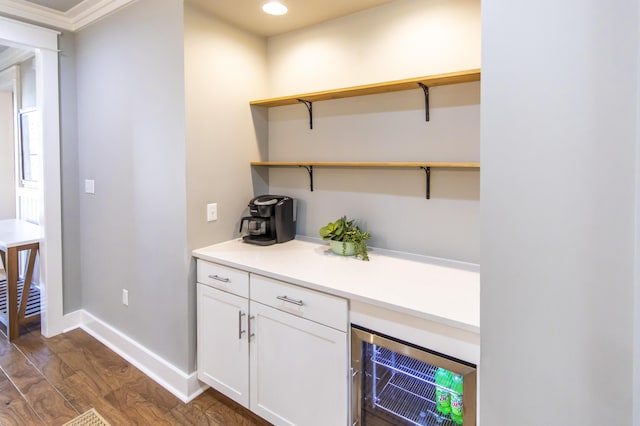 bar featuring white cabinets, crown molding, dark wood-type flooring, and wine cooler