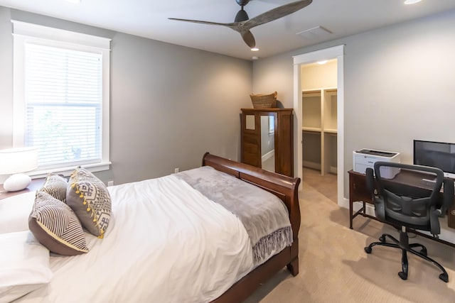 carpeted bedroom with ceiling fan, a spacious closet, and a closet