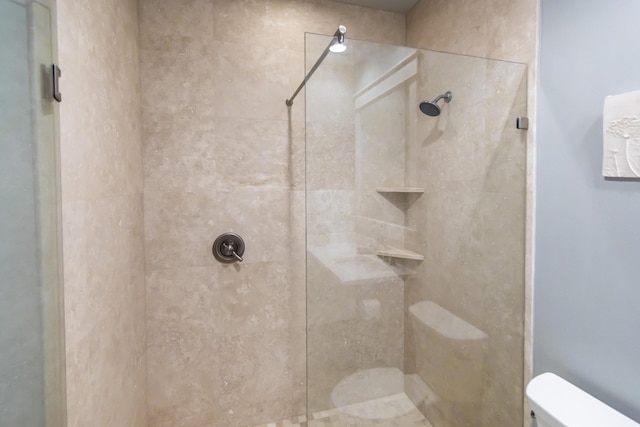 bathroom featuring toilet and tiled shower