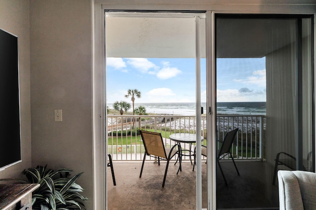 balcony with a water view and a view of the beach