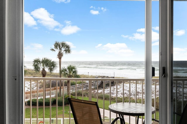 balcony featuring a water view and a beach view