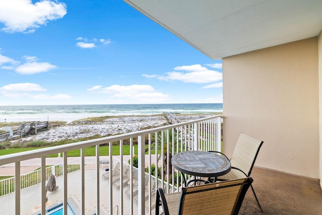 balcony featuring a water view and a view of the beach