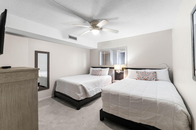 carpeted bedroom featuring ceiling fan and a textured ceiling